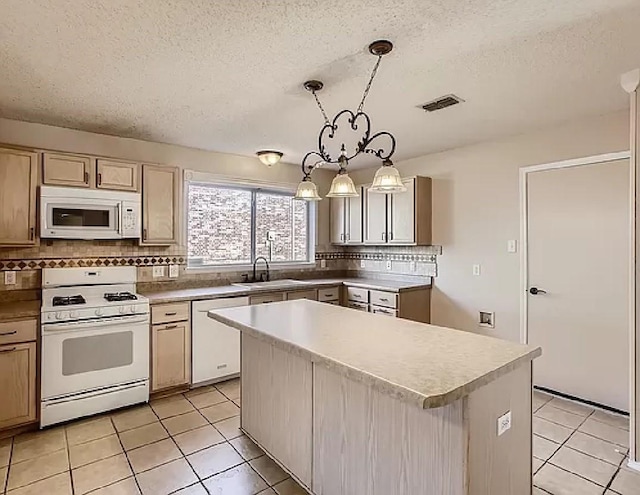 kitchen with light tile patterned floors, a center island, hanging light fixtures, and white appliances