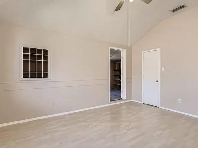 unfurnished room featuring ceiling fan, lofted ceiling, and light wood-type flooring