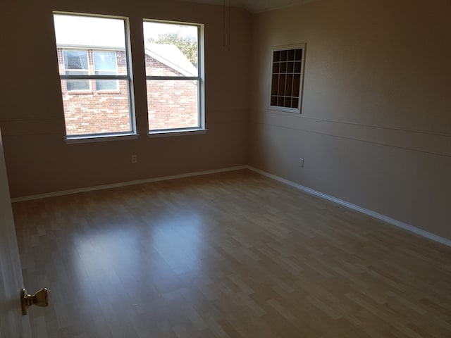 unfurnished room with wood-type flooring