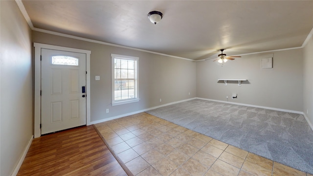 tiled foyer entrance featuring ceiling fan and ornamental molding