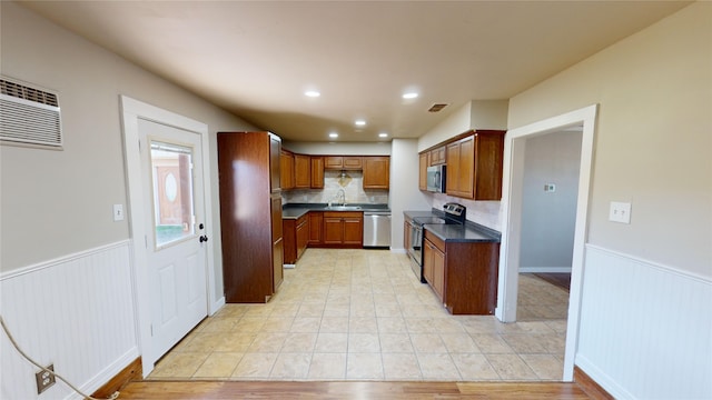 kitchen with stainless steel appliances, light hardwood / wood-style floors, backsplash, and sink