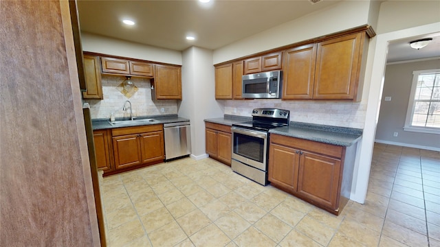 kitchen with stainless steel appliances, sink, backsplash, light tile patterned floors, and crown molding