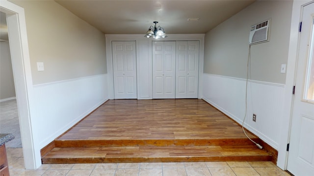 unfurnished bedroom with light tile patterned floors and an inviting chandelier