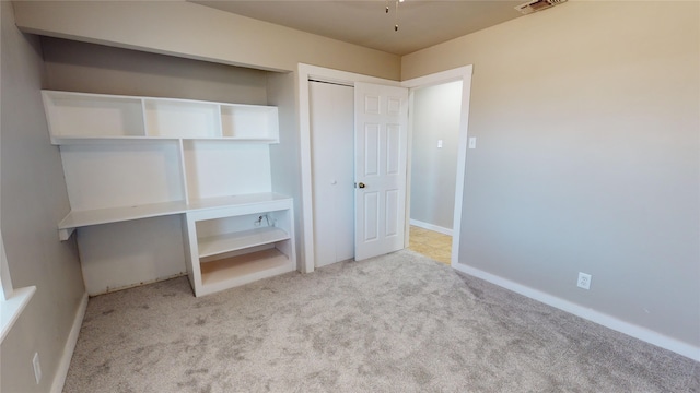 unfurnished bedroom featuring light carpet