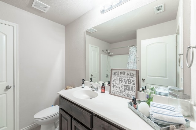 bathroom with a textured ceiling, toilet, vanity, and a shower with curtain