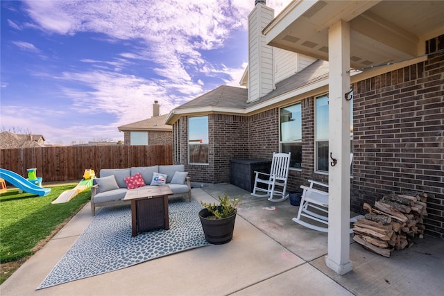 patio terrace at dusk featuring a playground and outdoor lounge area