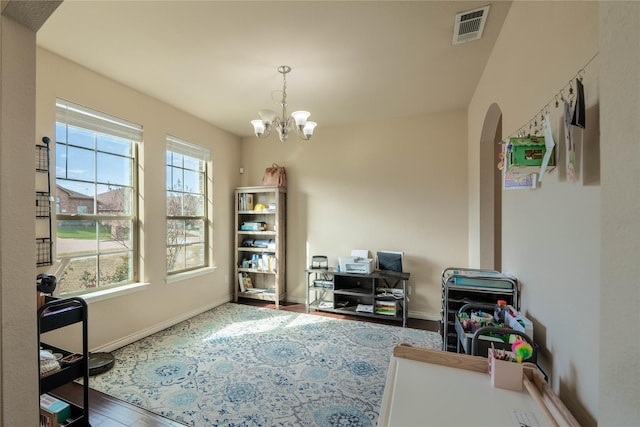 home office with hardwood / wood-style flooring and an inviting chandelier