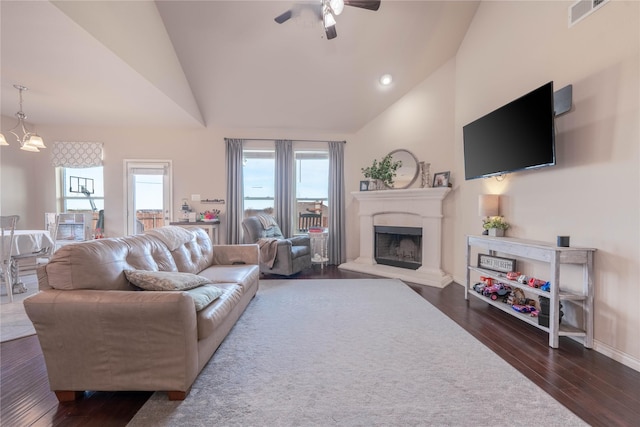 living room with high vaulted ceiling, dark hardwood / wood-style flooring, and ceiling fan with notable chandelier