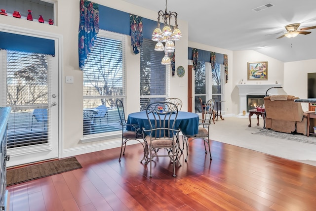 dining room featuring ceiling fan, wood-type flooring, and vaulted ceiling