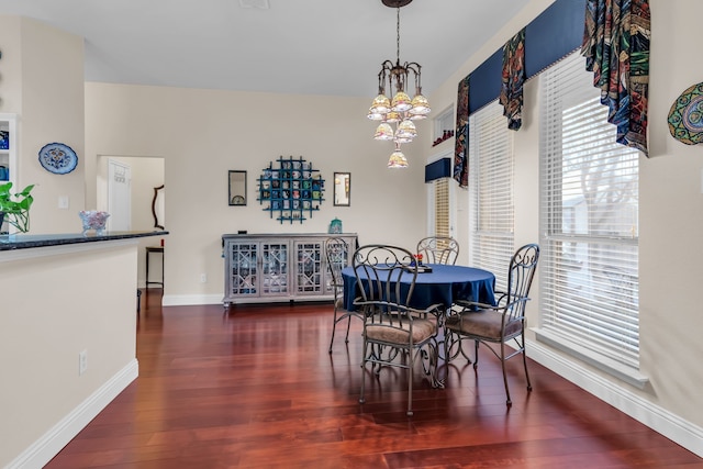 dining space featuring dark wood-type flooring and a chandelier