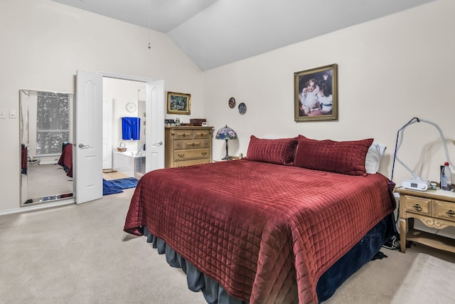 bedroom featuring ensuite bathroom and lofted ceiling