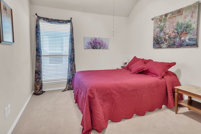 bedroom with carpet floors and lofted ceiling