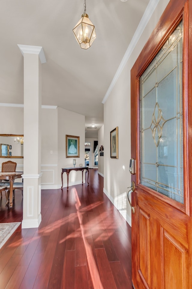 foyer with dark hardwood / wood-style flooring, crown molding, and ornate columns