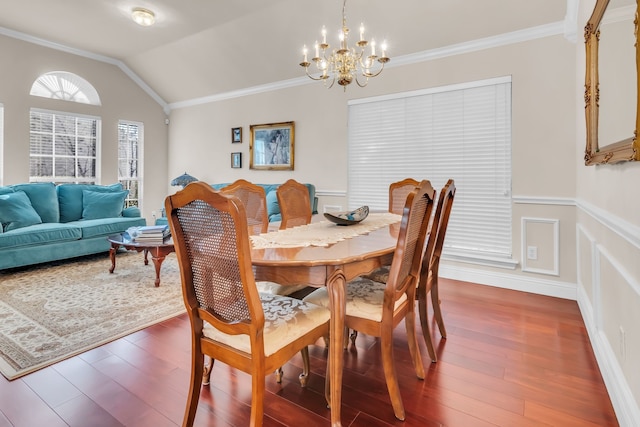 dining room featuring lofted ceiling, dark hardwood / wood-style floors, an inviting chandelier, and ornamental molding