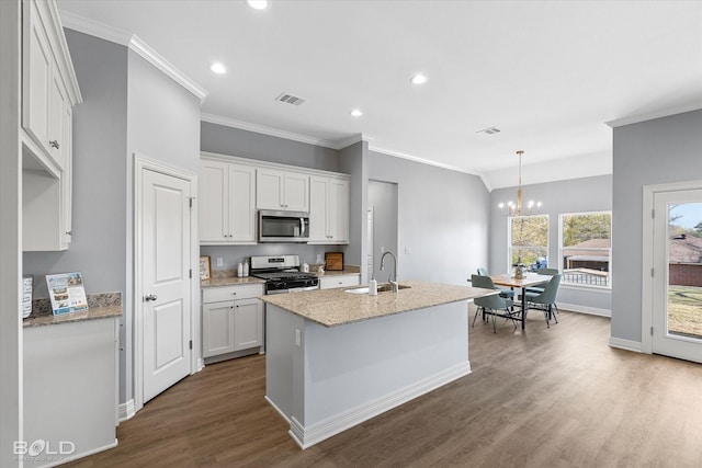 kitchen with an inviting chandelier, dark wood-style flooring, a sink, appliances with stainless steel finishes, and white cabinetry