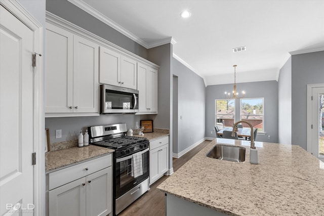 kitchen with visible vents, ornamental molding, a sink, appliances with stainless steel finishes, and a chandelier