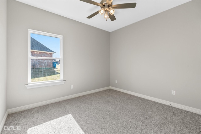 carpeted spare room with a ceiling fan and baseboards