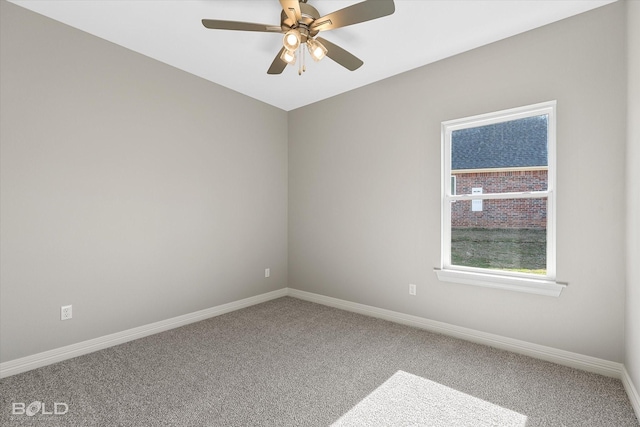 carpeted spare room with baseboards and a ceiling fan