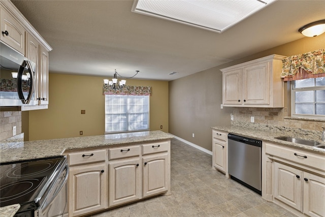 kitchen with tasteful backsplash, kitchen peninsula, sink, appliances with stainless steel finishes, and light stone counters