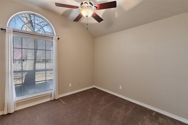 spare room with ceiling fan, lofted ceiling, and dark colored carpet