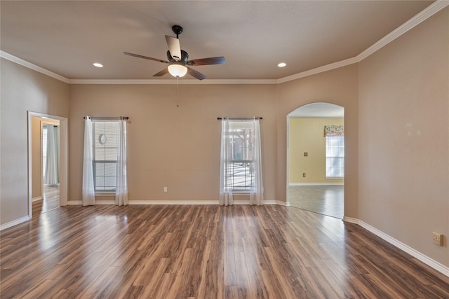 empty room with dark wood-type flooring, ornamental molding, and ceiling fan