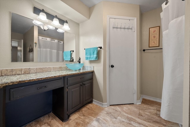 full bathroom with vanity and baseboards