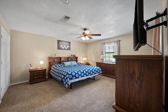 carpeted bedroom featuring a ceiling fan, visible vents, a textured ceiling, and baseboards