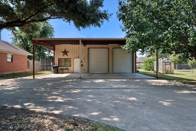 garage with a garage, fence, and a shed