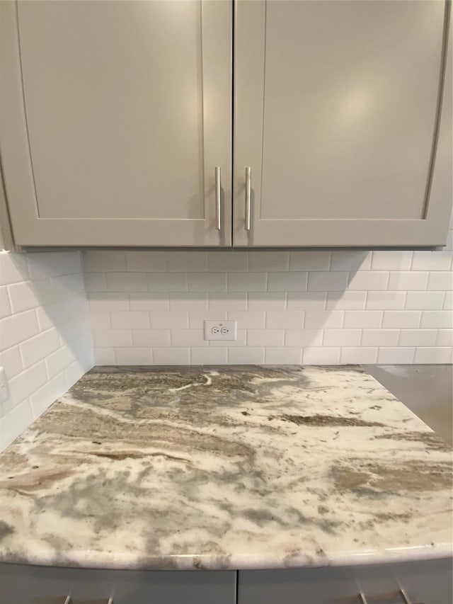 interior details with gray cabinetry and tasteful backsplash