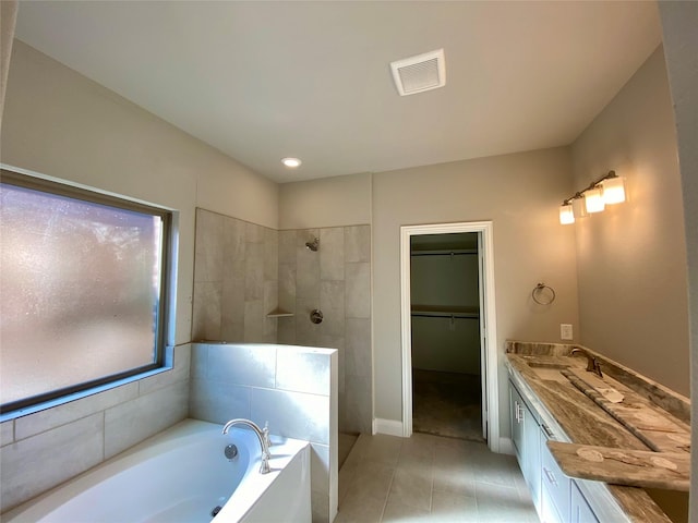 bathroom featuring plus walk in shower, tile patterned flooring, and vanity