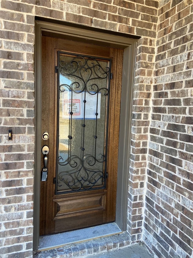 doorway to property featuring brick siding