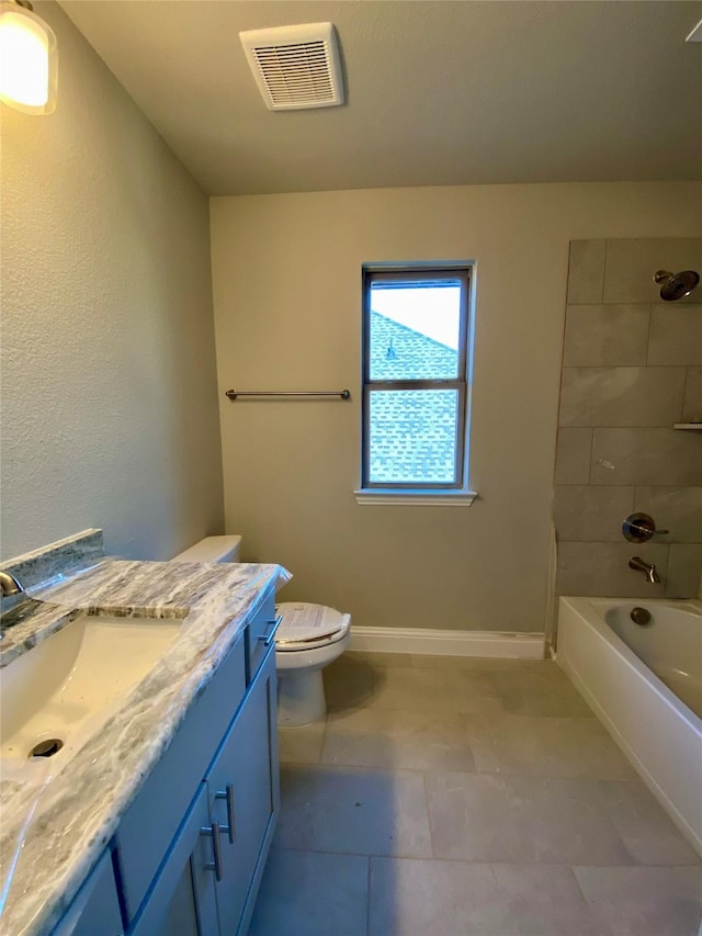 full bathroom with toilet, vanity, and tiled shower / bath