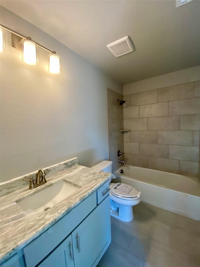 full bathroom featuring tile patterned floors, toilet, vanity, and tiled shower / bath