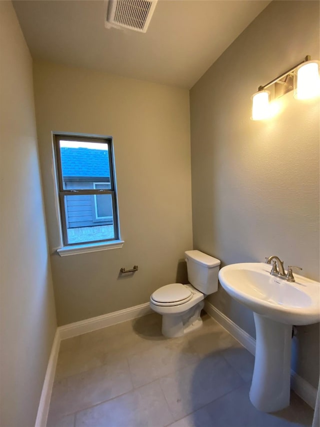 bathroom with toilet and tile patterned flooring