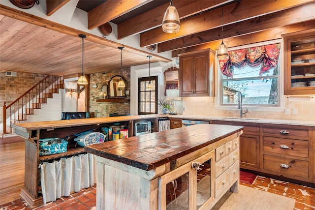 kitchen featuring brick floor, a sink, tasteful backsplash, and a kitchen island