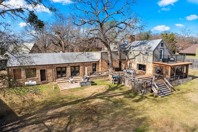 rear view of house with a sunroom, a lawn, and a patio