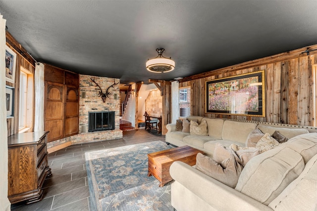 living room featuring a fireplace and wood walls