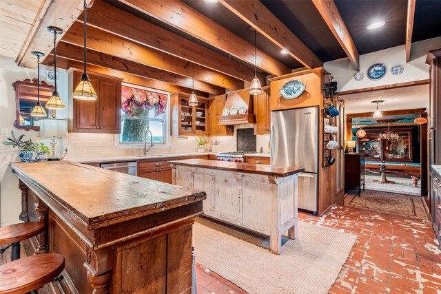 kitchen featuring a kitchen island, backsplash, decorative light fixtures, and sink