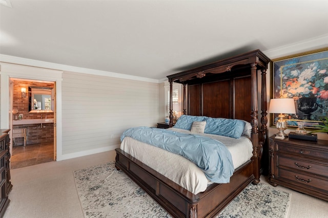 bedroom featuring light colored carpet, ornamental molding, and connected bathroom