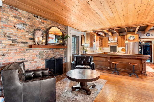 living room with light wood-type flooring, wooden ceiling, a fireplace, and sink