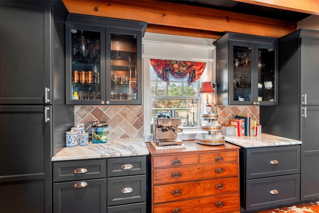 bar featuring light stone counters and tasteful backsplash