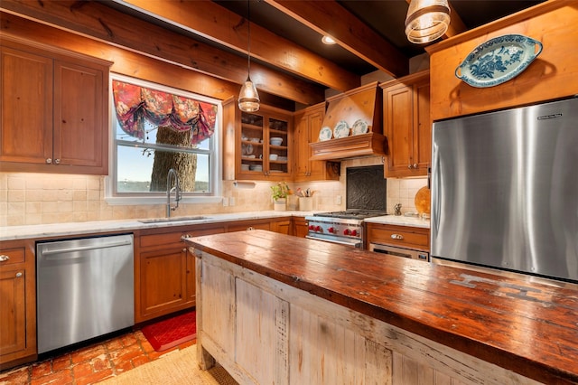 kitchen featuring wooden counters, stainless steel appliances, backsplash, custom range hood, and sink