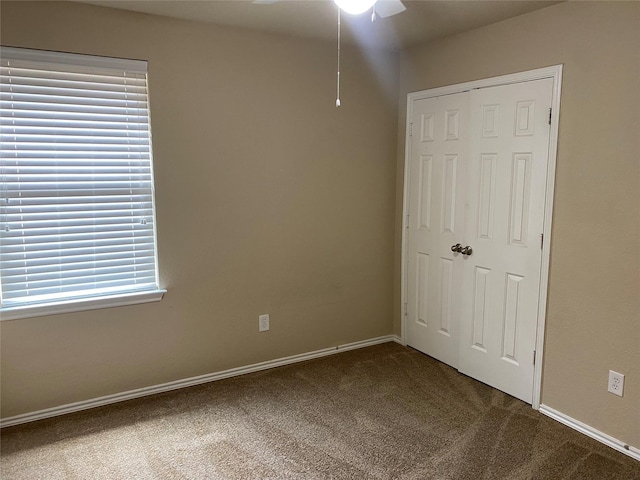 unfurnished bedroom featuring ceiling fan, a closet, and carpet floors