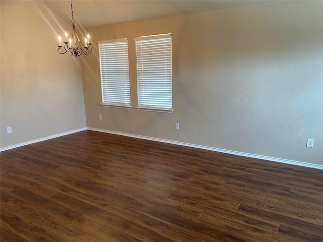 unfurnished room featuring dark hardwood / wood-style flooring and a chandelier