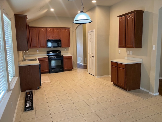 kitchen featuring light tile patterned floors, decorative light fixtures, sink, and black appliances