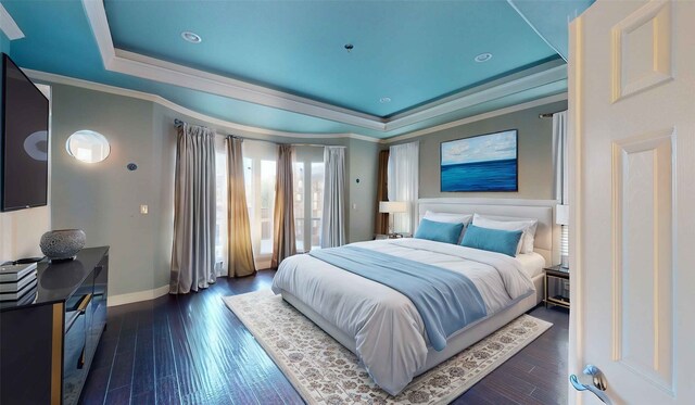 bedroom featuring a tray ceiling, dark hardwood / wood-style floors, and ornamental molding