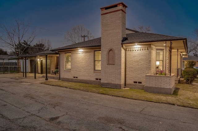 property exterior at dusk featuring a carport