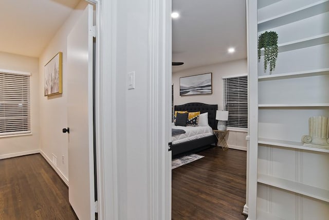 hall with built in features and dark hardwood / wood-style flooring