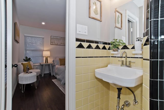 bathroom featuring sink, tile walls, and hardwood / wood-style floors