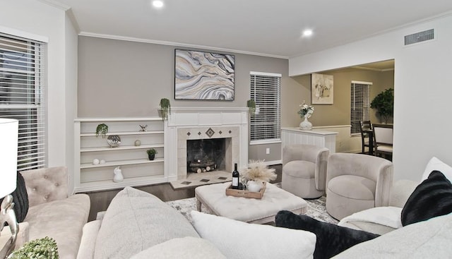 living room with hardwood / wood-style flooring, a tile fireplace, and crown molding